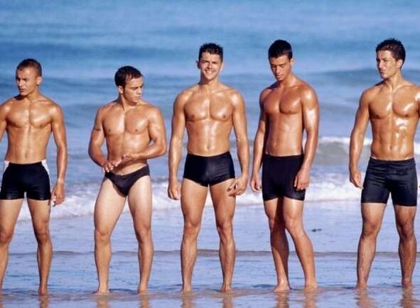 Hommes sur la plage avec des queues élargies